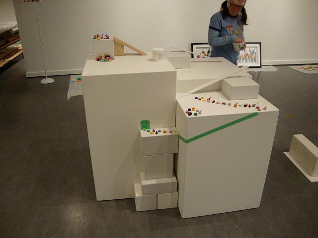install - an assent of polymen (4).JPG - we soon started to envison the "assent" ascending up various levels via ramps and bridges.  we then also considered a ramp around the outside of the plinth with the polymen coming from a "doorway" out of the plinth.  here we are using a 30 degree angle ramp (wood coloured) that turned out to be too steep and we played around with an idea to have the polymen drop off the top into a pile - lemming style...